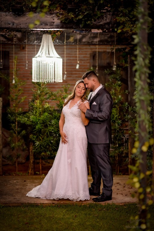 Casal no jardim sob um lustre