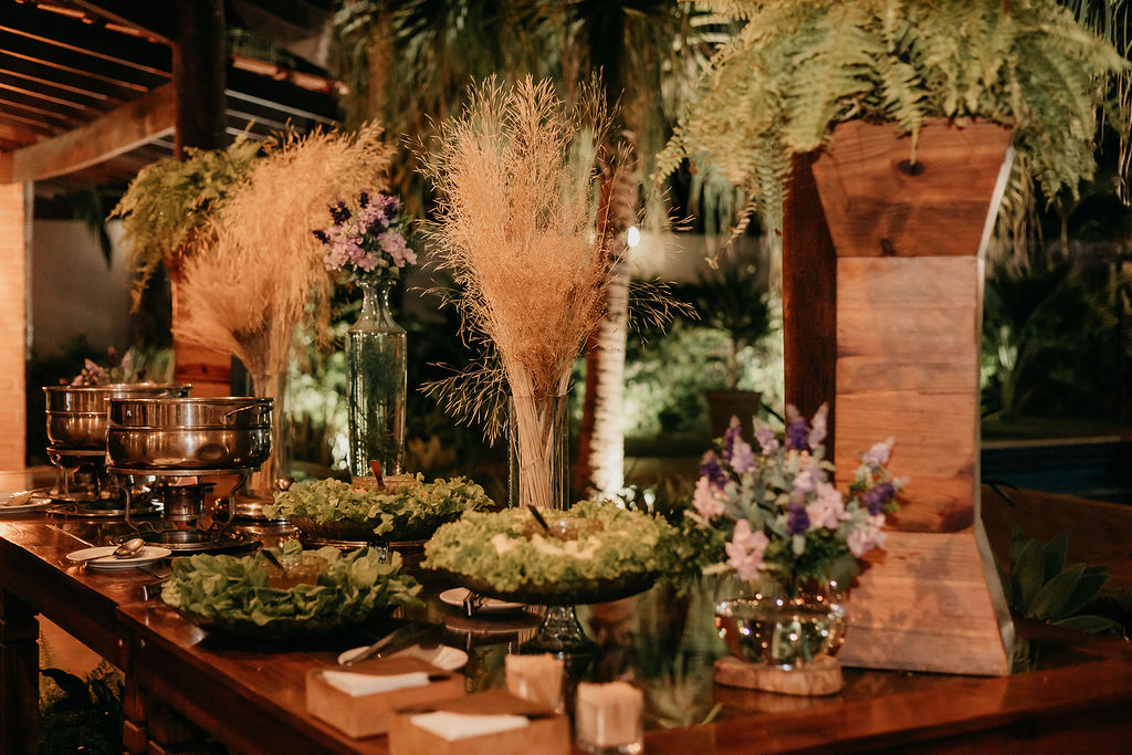 Buffet montado com decoração de flores e folhagens